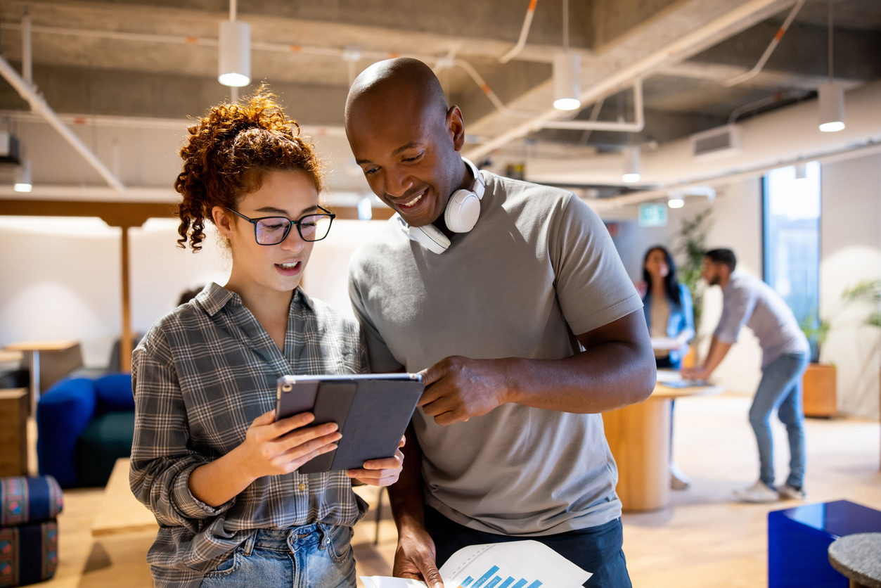 Team of workers looking at a business plan on a tablet computer while working together at the office